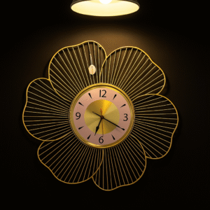 Decorative large metal wall clock in a golden floral petal design with a blush pink clock face and black numerals – elegant and modern home décor piece for living room or bedroom